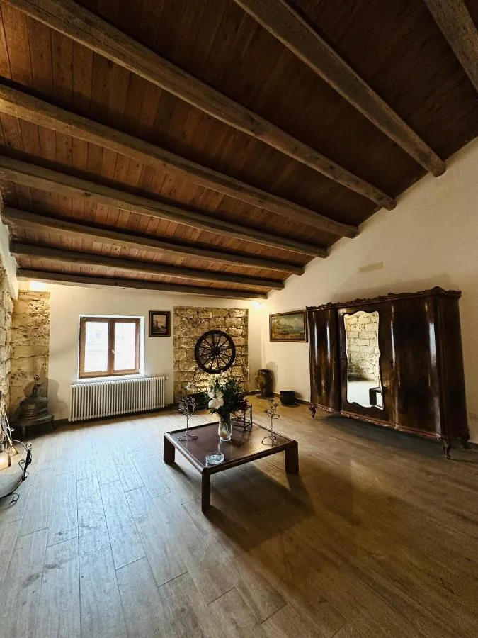 Salone con travi in legno, muri in pietra e armadio d'epoca