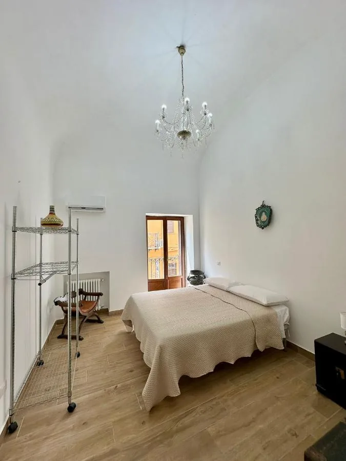 Camera matrimoniale con lampadario e porta-finestra